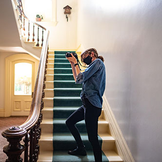 Ava Norgrove taking photos inside the mansion