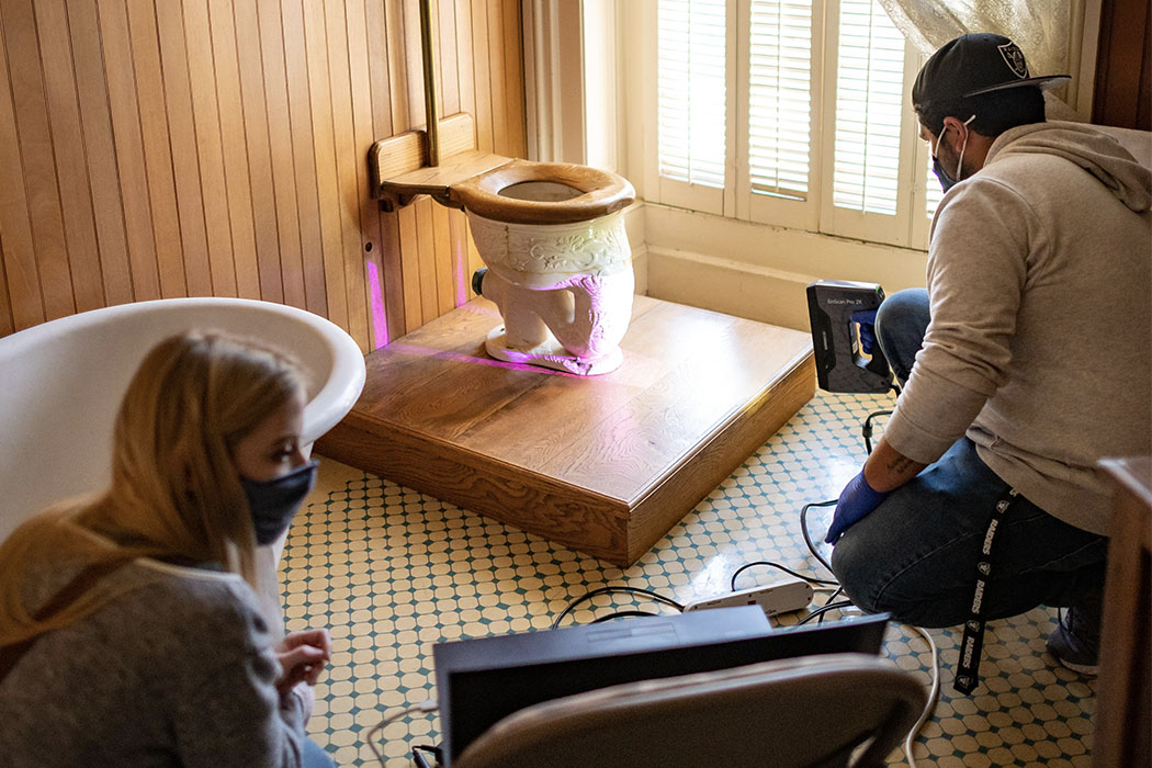 Two students in the bathroom of Bidwell Mansion lidar scanning an antique toilet